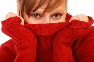 Smiling beautiful young woman in red sweater on white background