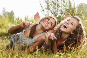 two girlfriends lying down on grass